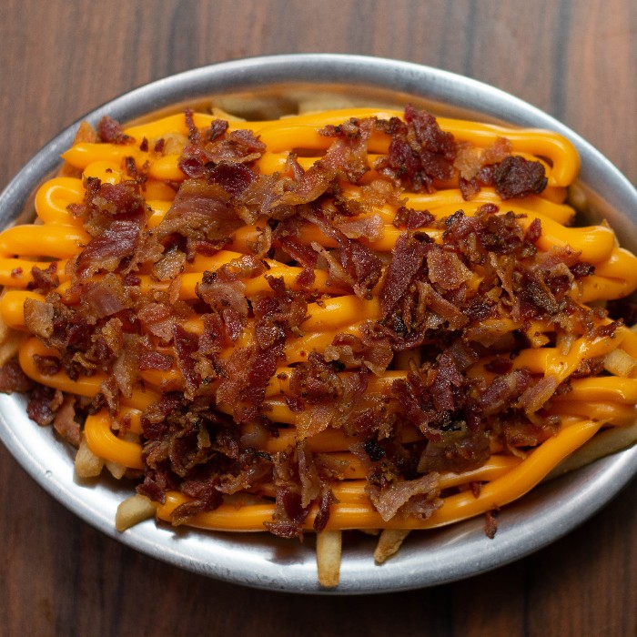 Porção de batatas fritas cobertas com cheddar e bacon